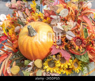 Nahaufnahme von Kürbissen, Blättern und Blumen, die den Herbst und Halloween feiern. Stockfoto