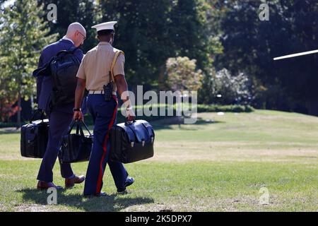 Ein militärischer Helfer des US-Marine Corps trägt die als „Fußball“ bekannten Codes für den nuklearen Start, als er Präsident Joe Biden am Freitag, den 7. Oktober, auf dem South Lawn des Weißen Hauses in Washington, DC, USA, auf den Marine One folgt. 2022. Biden sagte, dass die USA versuchen, eine „Off-Ramp“ für den russischen Präsidenten Wladimir Putin zu finden, und befürchtet, dass seine Drohungen zum Einsatz taktischer Atomwaffen real sind und zu „Armageddon“ führen könnten. Kredit: Ting Shen/Pool über CNP Stockfoto