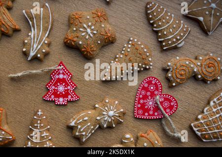 Set aus verschiedenen hausgemachten Weihnachtskeksen isoliert auf Holzhintergrund, Nahaufnahme mit Platz für Text. Neujahr Rahmen mit leckeren Lebkuchenkekse mit Gewürzen. Konzept für Winterurlaub Stockfoto