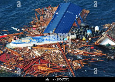 Eine Luftaufnahme der Trümmer eines Erdbebens der Stärke 8,9 und des anschließenden Tsunamis, der Nordjapan getroffen hat. Die Trümmer wurden von einem hubschrauberbasierten Such- und Rettungsteam des Flugzeugträgers USS Ronald Reagan (CVN 76) untersucht. Schiffe und Flugzeuge der Ronald Reagan Carrier Strike Group suchen in den Küstengewässern in der Nähe von Sendai, Japan, nach Überlebenden. PAZIFIK, 13. März 2011. Optimierte Version eines US- Navy-Foto. Kredit US Navy/A.Tidd Stockfoto