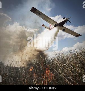 Wassertropfen auf vorgeschriebenem Feuer. National Interagency Fire Center Ein einmotoriger Lufttanker fällt auf ein vorgeschriebenes Feuer im Everglades National Park in Florida. Kredit: NPS Stockfoto