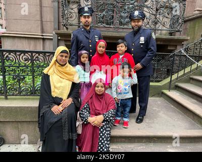 Zwei Polizisten der NYPD aus Bangladesch durchreisen mit ihren Familien bei der American Muslim Day Parade auf der Madison Avenue in New York City. Stockfoto