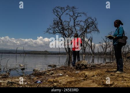 Ein Mitglied der Presse (L) und ein Wissenschaftler stehen während einer Feldereignis am Ufer des Lake Nakuru. Media for Science Health and Agriculture (MESHA), eine kenianische Medienorganisation, organisierte eine Faktenfindungs-Mission für Journalisten, um aus erster Hand die Auswirkungen des Klimawandels auf die biologische Vielfalt im Lake Nakuru National Park zu verstehen. Stockfoto