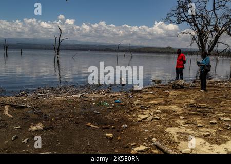 Ein Mitglied der Presse (L) und ein Wissenschaftler stehen während einer Feldereignis am Ufer des Lake Nakuru. Media for Science Health and Agriculture (MESHA), eine kenianische Medienorganisation, organisierte eine Faktenfindungs-Mission für Journalisten, um aus erster Hand die Auswirkungen des Klimawandels auf die biologische Vielfalt im Lake Nakuru National Park zu verstehen. Stockfoto