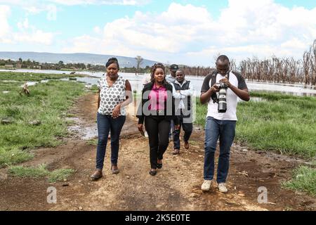 Journalisten verlassen Gebiete, die von den erhöhten Wasserständen des Nakuru-Sees während einer Feldereignis überflutet wurden. Media for Science Health and Agriculture (MESHA), eine kenianische Medienorganisation, organisierte eine Faktenfindungs-Mission für Journalisten, um aus erster Hand die Auswirkungen des Klimawandels auf die biologische Vielfalt im Lake Nakuru National Park zu verstehen. Stockfoto