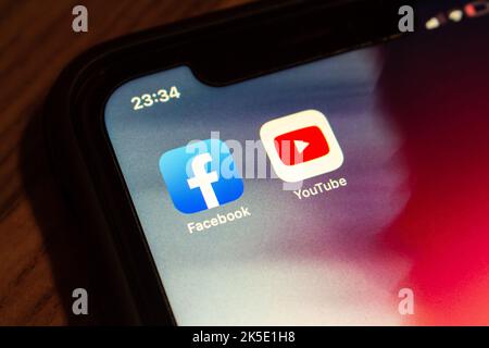 Vancouver, KANADA - 6 2022. Oktober : Facebook- und YouTube-Symbole auf einem iPhone-Bildschirm auf einem Holztisch. Stockfoto