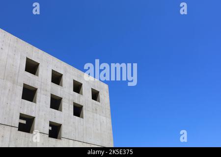 Blauer Himmel und graues Betongebäude Stockfoto