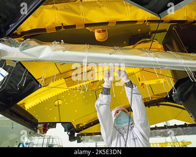 Vorbereitung des James Webb Space Telescope (JWST). Installation von Flug-Wärmedecken auf der Struktur, die den Sekundärspiegel des JWST in einem Reinraum in Northrop Grumman, Redondo Beach, Kalifornien, USA, unterstützt. Schnüren, die Decken an den Streben befestigen. Da die Decken gebunden (und auch genäht) sind, gehören die Mitglieder dieses Teams zu den einzigartigsten, die über Hintergründe verfügen, die Schneiderei und Kostümherstellung umfasst haben, bevor sie in der Luft- und Raumfahrtindustrie arbeiten. Eine optimierte Version eines NASA-Bildes vom erfahrenen Hauptfotografen Chris Gunn. Quelle: NASA/Chris Gunn. Nur für redaktionelle Zwecke Stockfoto