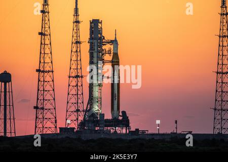 Artemis I auf dem Pad. Sonnenaufgang wirft am 21. März 2022 auf dem Launch Pad 39B im Kennedy Space Center der NASA in Florida ein warmes Licht um das Artemis I Space Launch System (SLS) und die Raumsonde Orion. Der SLS und Orion auf der mobilen Trägerrakete wurden auf dem Raupentransporter 2 für einen Vorrelaunch-Test, genannt eine NassGeneralprobe, zum Pad transportiert. Artemis I wird der erste integrierte Test der Raumfahrzeuge SLS und Orion sein. Bild: NASA/BSmegelsky Stockfoto