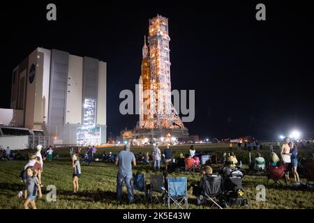 Geladene Gäste und NASA-Mitarbeiter beobachten, wie die NASA-Rakete zum Start von Space Launch System (SLS) mit dem Orion-Raumschiff an Bord am Dienstag, den 16. August 2022, im NASA-Weltraumzentrum Kennedy in Florida aus dem Vehicle Assembly Building zum Launch Pad 39B ausgerollt wird. Der Artemis I-Flugtest der NASA ist der erste integrierte Test der Tiefenraumexplorationssysteme der Agentur: Die Raumsonde Orion, die SLS-Rakete und die unterstützenden Bodensysteme. Der Start des unbemalten Flugtests ist für den 29. August geplant. Stockfoto