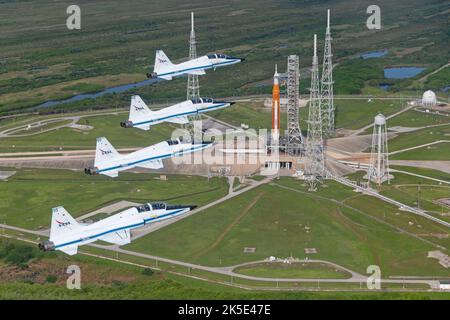 NASA T-38s fliegen in Formation über der Space Launch System (SLS) Rakete auf dem Launch Pad 39B, Kennedy Space Center, Florida, USA. Artemis 1, offiziell Artemis I, ist eine geplante unbemannte Mondorbiting-Mission, der erste Weltraumflug im Artemis-Programm der NASA und der erste Flug der Weltraumrakete der Agentur und der kompletten Orion-Raumsonde. Bild: 23. August 2022. Eine optimierte Version eines Originalbildes der NASA. Quelle: NASA/ JValcarcel Stockfoto