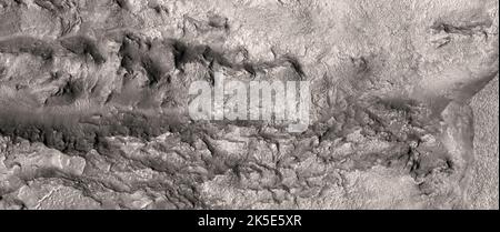 Marsatlandschaft. Dieses HiRISE-Bild zeigt geschichteten Grundgestein nordwestlich der Hellas-Region, dem Mars.Dieses Bild kann helfen, ein Mosaik des Gebiets zu vervollständigen, da andere benachbarte Bilder auch aufschlussreiche Aufnahmen des Grundgesteins zeigen.Dieses Bild ist weniger als 5 km (3 mi) weit entfernt und liegt 255 km (158 mi) über der Oberfläche. Eine einzigartige optimierte Version von NASA-Bildern. Quelle: NASA/JPL/UArizona Stockfoto