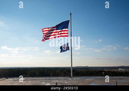 Die US- und NASA-Flaggen auf Gebäude 4200 im NASA Marshall Space Flight Center in Huntsville, Alabama, wurden am 21. Januar 2022 in den Ruhestand verabschiedet. Diese Bilder zeigen Mitarbeiter des Zentrallabors, die die Flaggen in Gebäude 4200 senken, dem ursprünglichen Zentrallabor- und Bürogebäude von Marshall, das seit 1963 als Hauptquartier von Marshall diente. Dieses Gebäude wird im Laufe dieses Jahres abgerissen. Am 26. Januar 2022 fand eine Zeremonie zur Anhebung der Flagge anlässlich der Verlegung des Hauptquartiers von Marshall nach Gebäude 4221 statt. Die Türen zum Gebäude 4221 wurden am Tag der Erde, dem 22. April 2019, eröffnet. Stockfoto