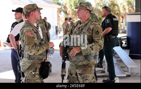 Florida Army National Guard Spc. Daniel Crews und Staff Sgt. James Long wird Bravo Truppe zugewiesen, 1. Squadron, 153. Calvary Regiment Gespräch an einem Einsatzort während der Notfallmaßnahmen des Unruhres Ian in Pine Island Florida 3, Oktober 2022. Die Zerstörung von Pine Island führte dazu, dass Soldaten der Nationalgarde der Florida Army auf dem Hubschrauber der US Army Boeing CH-47 Chinook einflogen, um Operationen einzurichten und die Bewohner auf jede ermögliche Weise zu unterstützen. (Foto der Nationalgarde der Florida Army von Staff Sgt. Cassandra Vieira) Stockfoto