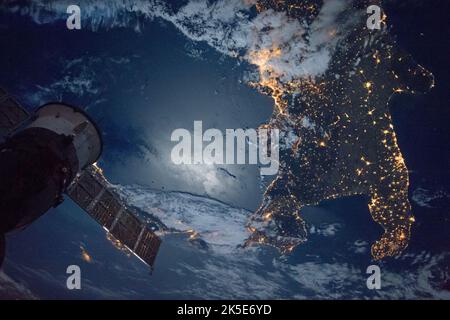 Die Südspitze Italiens ist in diesem Bild sichtbar, das die Expedition 49-Besatzung an Bord der Internationalen Raumstation am 17. September 2016 aufgenommen hat. Die hell erleuchtete Stadt Neapel ist im unteren Teil des Bildes zu sehen. Im Vordergrund ist eine russische Sojus-Raumsonde zu sehen. Eine einzigartige Version eines Originalbildes der NASA. Quelle: NASA Stockfoto