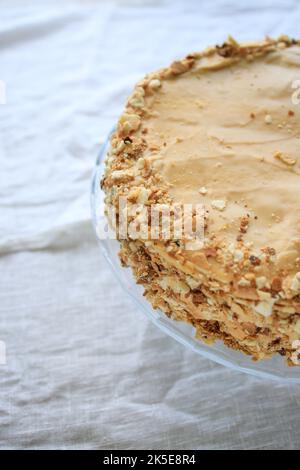 napoleonkuchen, rundes Ganzes mit Karamellcreme auf weißem Hintergrund. Platz zum Kopieren. Stockfoto