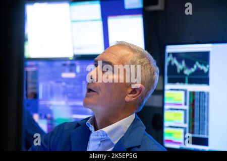 New York, USA. 7. Oktober 2022. Ein Händler arbeitet am Boden der New York Stock Exchange (NYSE) in New York, USA, 7. Oktober 2022. Die US-Aktien sind am Freitag stark gesunken, da ein solider Beschäftigungsbericht im September die Befürchtungen schürte, dass die US-Notenbank mit Zinserhöhungen weiterhin aggressiv vorgehen würde. Der Dow Jones Industrial Average sank um 630,15 Punkte oder 2,11 Prozent auf 29.296,79. Der S&P 500 sank um 104,86 Punkte oder 2,80 Prozent auf 3.639,66. Der Nasdaq Composite Index vergab 420,91 Punkte oder 3,80 Prozent auf 10.652,40. Quelle: Michael Nagle/Xinhua/Alamy Live News Stockfoto