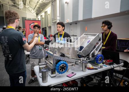 Studenten des Miami-Dade College in Kendall bereiten ihren robotischen Bergmann auf den Zug vor, um während des LUNABOTICS-Wettbewerbs der NASA am 24. Mai 2022 im Center for Space Education in der Nähe des Kennedy Space Center Visitor Complex in Florida in der Bergbauarena zu graben. Mehr als 35 Teams aus den USA haben ferngesteuerte Roboter für den Bergbau entwickelt und gebaut. Teams nutzen ihre autonomen oder ferngesteuerten Roboter, um in einem überdimensionalen Sandkasten zu manövrieren und zu graben, der mit Steinen und simuliertem Mondboden oder Regolith gefüllt ist. Ziel der Herausforderung ist es zu sehen, welcher Roboter des Teams colle kann Stockfoto