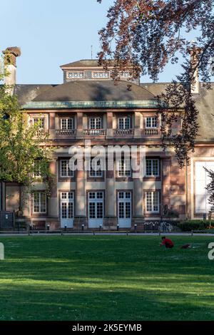 Eine schöne vertikale Aufnahme des Orangerie-Parks in Straßburg, Frankreich mit antiken Gebäuden an einem sonnigen Sommertag Stockfoto