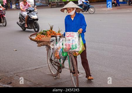 Straßenverkäufer mit Bambushut und Fahrrad, Hai Phong, Vietnam Stockfoto