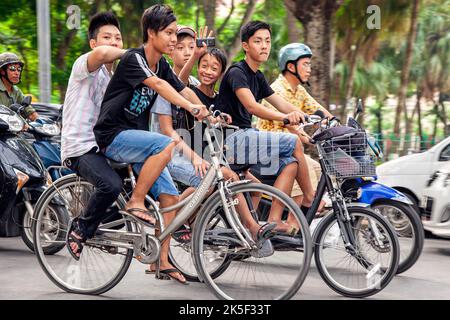 Junge Jungen, die im Straßenverkehr Fahrrad fahren, Hai Phong, Vietnam Stockfoto