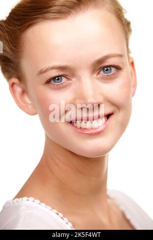 Porträt der Schönheit. Beschnittenes Studioportrait einer schönen jungen Frau, die weit auf die Kamera lächelt. Stockfoto
