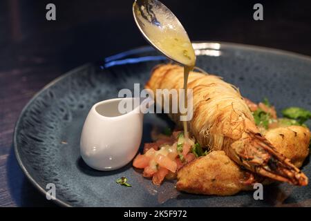 Eine Nahaufnahme von Garnelen in Kataifi-Paste mit Teriyaki-Sauce auf dem Teller Stockfoto