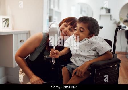 Frau, Kind Behinderung und Spiegel im Salon für Selbstliebe glücklich mit dem Service nach Friseur, Friseur oder Stylist schneidet Haare. Behindert, Zerebralparese Stockfoto