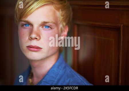 Nordisches, gutes Aussehen. Nachdenklicher und hübscher junger blonder Kerl mit sehr blauen Augen. Stockfoto