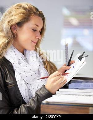 Eine junge Künstlerin, die verschiedene Schreibgeräte in einem Kunstladen ausprobiert. Stockfoto