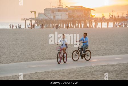 Biker am Santa Monica State Beach vor dem Santa Monica Pier. Dies ist ein ikonischer strand an der pazifikküste in Los Angeles, CA, USA Stockfoto
