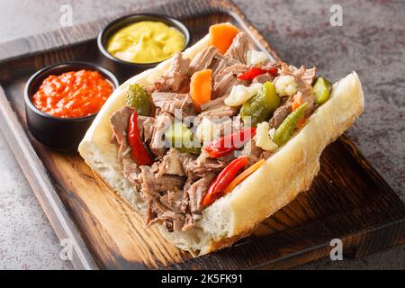 Das berühmte italienische Rindfleisch-Sandwich von Chicago mit Giardanarra, das aus der Nähe auf das Holztablett auf dem Tisch gebeizt wurde. Horizontal Stockfoto