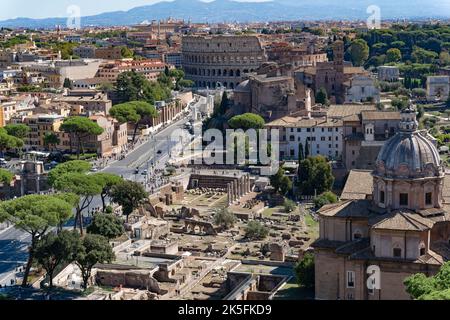 Aus der Vogelperspektive von Rom mit dem Kolosseum, den Ruinen des Forums Romanum und der Skyline der Stadt an einem sonnigen Herbsttag Stockfoto