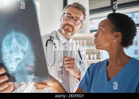 Ärzte für Gehirn, Röntgen und Neurologie bei einer Besprechung zur Schädelverletzung in der Notaufnahme eines Krankenhauses. Diversity, Krebs und Gesundheitsmedizin Stockfoto