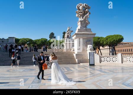 Ein Paar in Hochzeitskleidung im Victor Emmanuel II Monument, (Altare della Patria oder Hochzeitskuchen), Rom, Italien Stockfoto