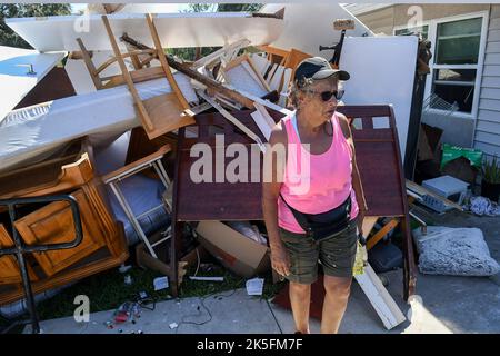 Kissimmee, Usa. 07. Oktober 2022. Mirta Marangi steht vor einem Stapel ihrer Möbel, der ruiniert wurde, als mehrere Meter Wasser vom US-Bundesstaat Kissimmee, Florida, ihre Wohnung in den Kissimmee Homes Apartments in Kissimmee überflutete. Die meisten Wohnungen erlitten erhebliche Hochwasserschäden, und die Bewohner wurden angewiesen, ihre Häuser bis heute zu evakuieren, damit die Arbeiter mit dem Reinigungs- und Reparaturprozess beginnen können. (Foto von Paul Hennessy/SOPA Images/Sipa USA) Quelle: SIPA USA/Alamy Live News Stockfoto