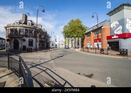 06.10.2022 St Helens, Merseyside, Großbritannien Wilkinson-Shop in der Cotham St in der St Helens mit dem Rathaus im Hintergrund Stockfoto