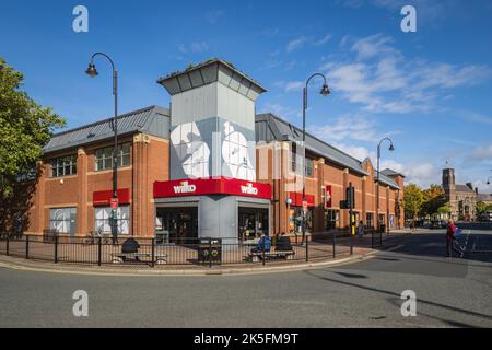 06.10.2022 St Helens, Merseyside, Großbritannien Wilkinson-Shop in der Cotham St in der St Helens mit dem Rathaus im Hintergrund Stockfoto