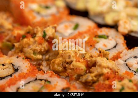 Eine Reihe verschiedener Rollentypen in einer Schachtel. Blick von oben auf verschiedene Portionen vegetarischer und Fischbrötchen. Nahaufnahme, selektiver Fokus. Stockfoto