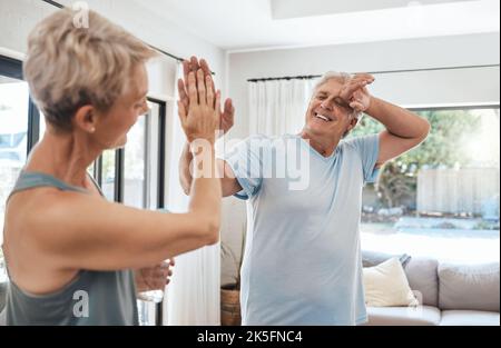 High Five, Fitness-Erfolg und Senior-Paar nach Hause Training, Bewegung und Training im Haus Lockdown. Lächeln, glücklich oder gesundheitsfördernd Ruhestand Stockfoto