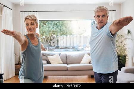 Yoga, Training und ein Paar, das zu Hause Sport macht, um aktiv zu bleiben. Alte Frau und Mann machen im Wohnzimmer Fitnesstraining. Gesund Stockfoto