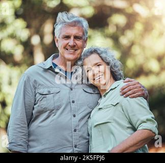 Seniorenpaar, Liebe und Umarmung in der Natur zusammen für Unterstützung, Pflege und Lächeln im Outdoor-Park. Porträt von Freude, Glück und alten Mann und Frau glücklich Stockfoto