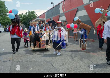 Marschiere in traditioneller Kleidung und mit hölzernen Tierstatuen.bei der ecuadorianischen Parade NYC 2022 in Queens, New York. Stockfoto