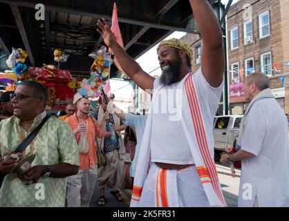 Ekstatische Hare Krishna Hindus tanzen und spielen Musik unter der erhöhten U-Bahn bei der jährlichen Ratha Yatra Parade in Richmond Hill, Queens, New York. Stockfoto