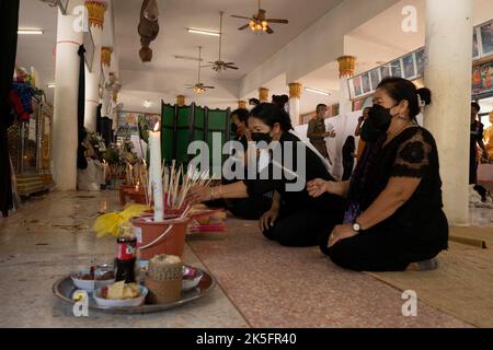 Nong Bua Lamphu, Thailand. 08. Oktober 2022. 8. Oktober 2022, Uthai Sawan, Nong Bua Lamphu, Thailand: Trauernde beten und stellen brennenden Weihrauch vor gekühlten Särgen während des ersten vollen Tages der Beerdigungsrechte für die Opfer des Massakers im Kindertageszentrum Uthai Sawan im Tempel Wat Rat Samakee in Nong Bua Lamphu, Thailand. Der Angreifer benutzte eine Kombination aus Gewehren und Messern, um mindestens 38 Menschen in der Kindertagesstätte zu töten, wobei die meisten der Opfer kleine Kinder waren. (Bild: © Adryel Talamantes/ZUMA Press Wire) Bild: ZUMA Press, Inc./Alamy Live News Stockfoto