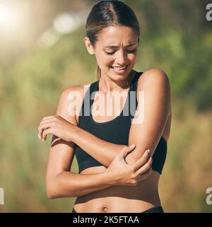 Fitness, Frau und Ellbogen bei Schmerzen, Verletzungen oder Sportunfall von Läufern, die unter Gelenkschmerzen im Freien leiden. Athletische Frau, die schmerzhafte Muskelpartien hält Stockfoto