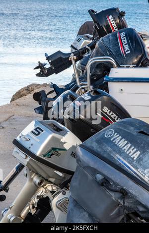 Außenbordmotoren in einer Reihe auf der Rückseite von Booten in einem Hafen, Motoren, Motoren, Außenbordmotoren, Kopierraum. Stockfoto