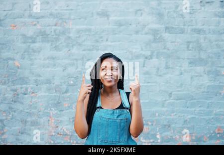 Schwarze Frauenfinger zeigen auf Werbemockup oder Marketingfläche auf blauem Outdoor-Jugendstil. Happy gen z oder afrikanische Teenager Hände Stockfoto