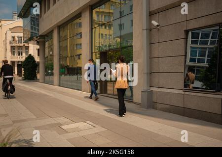 Eine schöne Geschäftsfrau und ein Geschäftsmann hängen nach der Arbeit, an einem schönen sonnigen Tag Stockfoto
