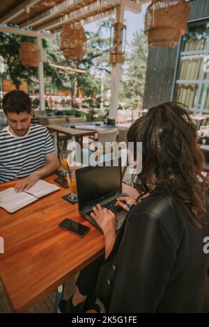 Zwei Geschäftspartner, die am Tisch arbeiten, während sie im Café sitzen Stockfoto
